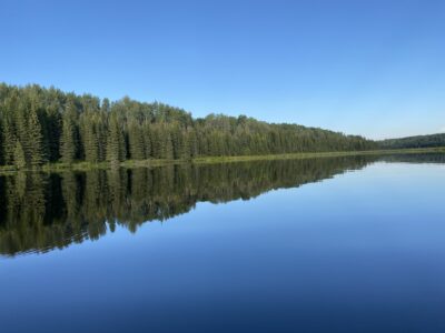 Image of a body of waters with a mirror image reflection of trees. The link takes you to the image page with another link to see the image at full size. The link takes you to the image page with another link to see the image at full size.