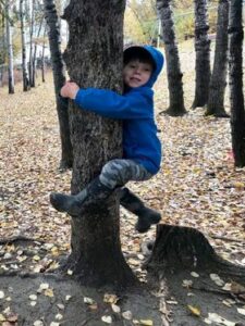 Sixth Place Entry. Picture of a young boy hugging a tree on a warm fall day. The link takes you to the image page with another link to see the image at full size.